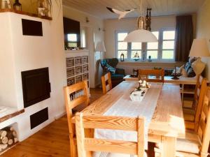 cocina y comedor con mesa de madera y sillas en Haus Am Deich Modern retreat, en Cadenberge