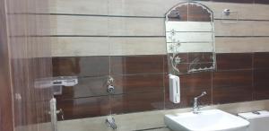 a bathroom with a sink and a mirror at Modernio Guest House Noida Extension in Greater Noida