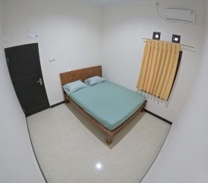 um pequeno quarto com uma cama e uma janela em Griya Sukoharjo Homestay Jogja em Ngemplak