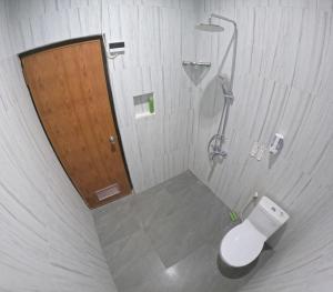 uma casa de banho com um chuveiro e um WC. em Griya Sukoharjo Homestay Jogja em Ngemplak