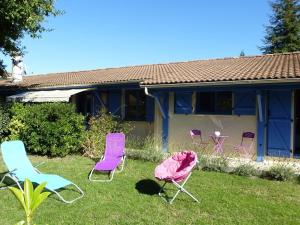 grupa krzeseł w ogrodzie domu w obiekcie Villa Alluro w mieście Andernos-les-Bains