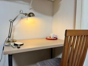 a desk with a lamp and a cup on it at Guest room Kurume in Miimachi