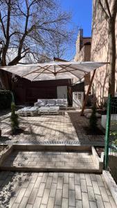patio z dużym parasolem i ławkami w obiekcie Charming Place Cotroceni w Bukareszcie