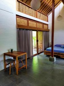 een slaapkamer met een bed, een bureau en een tafel bij Pool House Studios in Kuta Lombok