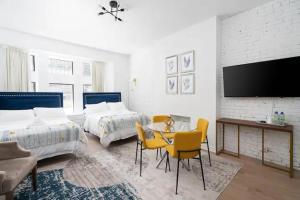 um quarto com 2 camas, uma mesa e cadeiras em The Dru em Montreal