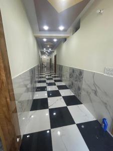 a hallway with a black and white checkered floor at Moonlight hotel greater Noida in Greater Noida