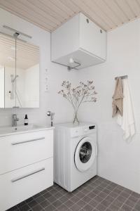 uma lavandaria branca com uma máquina de lavar roupa em 2BR design home 400 m from train station Tikkurila em Vantaa