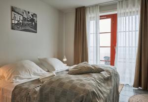 1 dormitorio con cama y ventana grande en Hotel Klippen, en Gudhjem
