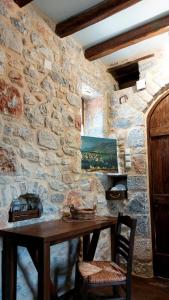 a stone wall with a wooden table in a room at Studio Tsiliviani in Loukádhika