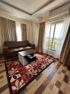 a living room with a couch and a large window at Sapphire Stayss in Yelagiri