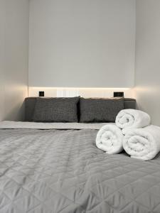 a bed with two towels on top of it at Апартаменти VIP з видом на Театр - Мережа HELEN in Poltava