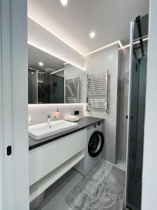 a white bathroom with a sink and a shower at Апартаменти VIP з видом на Театр - Мережа HELEN in Poltava +28 photos