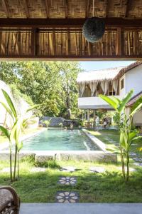 uitzicht op een zwembad in een tuin bij Pool House Studios in Kuta Lombok