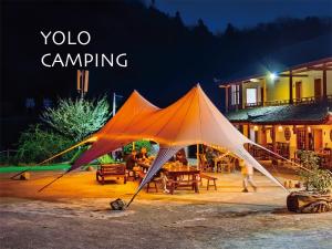 a large orange and white tent in a yard at night at Zhangjiajie YOLO Resort--Within Zhangjiajie National Forest Park in Zhangjiajie