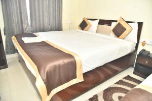 a bedroom with a large bed with white sheets at Hotel Buddha Vibrant in Deoghar