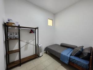 ein Schlafzimmer mit einem Bett und einem Sofa darin in der Unterkunft Homestay D'Rumahku in Kampong Parit