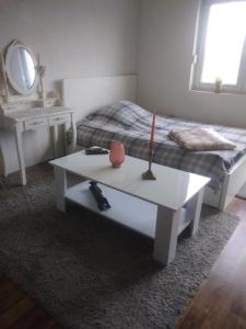 Landhaus في Bosanska Dubica: غرفة بسرير وطاولة عليها شمعة