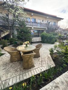 a patio with a table and chairs and a building at Pensiunea Drobeta in Drobeta-Turnu Severin