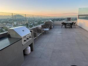 balcón con mesas y sillas y vistas a la ciudad en PuntaAcero Fundidora y Cintermex, en Monterrey
