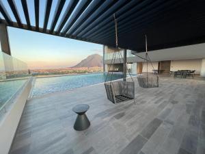 a room with a swing and a view of a building at PuntaAcero Fundidora y Cintermex in Monterrey