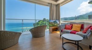 sala de estar con sofá, sillas y ventana grande en My Ocean Villa 月牙桐海景民宿 en Ruifang