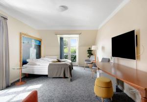 Habitación de hotel con cama y TV de pantalla plana. en Hotel Ringkøbing en Ringkøbing