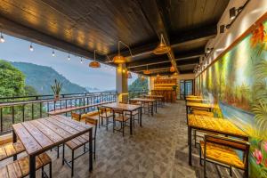 a restaurant with tables and chairs on a balcony at Cat Ba Xanh Spring Garden Hotel in Cat Ba