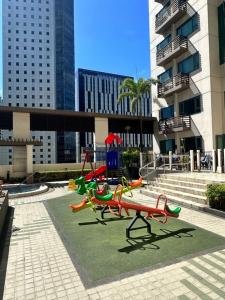 un parque infantil en medio de una ciudad con edificios altos en The Pearl - BGC McKinley Park 2BR en Manila