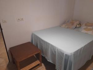 Dormitorio pequeño con cama y mesa en HINAMOE LODGE, en Avatoru