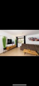 a living room with a couch and a table at הוילה הסודית שלי in Kefar H̱ananya