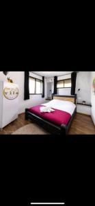 a bedroom with a large bed with a red blanket at הוילה הסודית שלי in Kefar H̱ananya