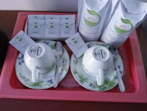 a pink tray with two tea cups and detergent at Power Zone Guest House in Matale
