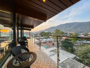 瑞诗凯诗Green View by Green Tree Hotels的带椅子的阳台，可欣赏城市景观