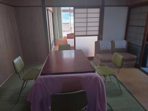 a table and chairs in a room with a purple table cloth at 名高儀の宿 in Iwaki