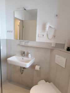 リュッベンにあるKastanienhof Lübbenの洗面台、トイレ、鏡のあるバスルーム +23枚の写真