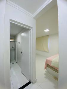 een witte kamer met een bed en een glazen deur bij Apartamento Amplo Luzia Próx Shopping Jardins in Aracaju