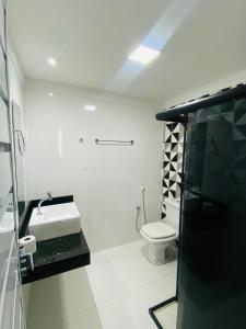 een witte badkamer met een toilet en een wastafel bij Apartamento Amplo Luzia Próx Shopping Jardins in Aracaju