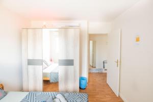 - une chambre avec une porte coulissante et un lit dans l'établissement Superbe Appartement près du Stade de France et Paris, à Villetaneuse