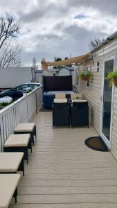 a deck with benches and a bed on a house at SKYLA VISTA Clacton-on-Sea in Clacton-on-Sea