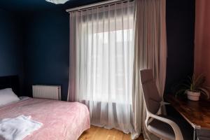 1 dormitorio con cama, escritorio y ventana en Milton Keynes Cosy Guest House en Milton Keynes