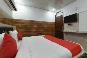 a bedroom with a large bed with red pillows at HOTEL Krishna at Sector 34 in Noida