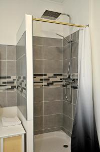 a shower with a shower curtain in a bathroom at La bella Vidda in Arromanches-les-Bains +15 photos
