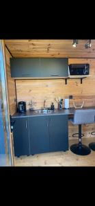 una pequeña cocina con fregadero y escritorio en La Tiny house, en Ardres