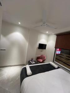 a bedroom with a large bed and a red chair at HOTEL IVORY INN NEW DELHI At IGI AIRPORT in New Delhi