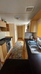 a small kitchen with a sink and a stove at SKYLA VISTA Clacton-on-Sea in Clacton-on-Sea