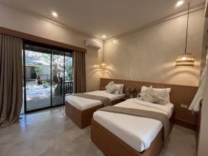 two beds in a room with a balcony at Lio Villas Resort in El Nido