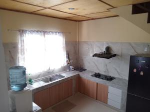 a small kitchen with a sink and a refrigerator at Alice Villa in Tuk Tuk