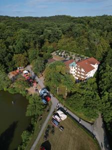 una vista aérea de una casa con coches estacionados junto a un lago en Kreuzberghof en Tiefenbach