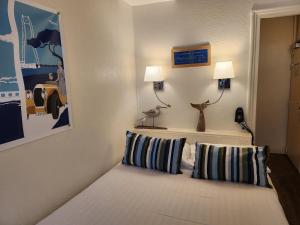 a room with a couch with two pillows at Logis Hôtel Lafayette Rochefort France in Rochefort +71 photos