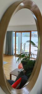 New luxury waterfront accommodation في دنيدن: مرآة تعكس أريكة في غرفة المعيشة